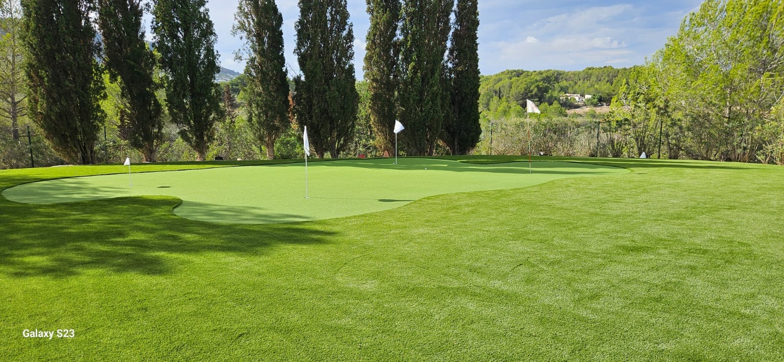 Golf course putting green with cypress trees Spain